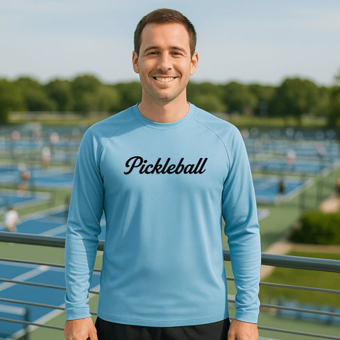 Man wearing a blue 'Pickleball' shirt on a pickleball court